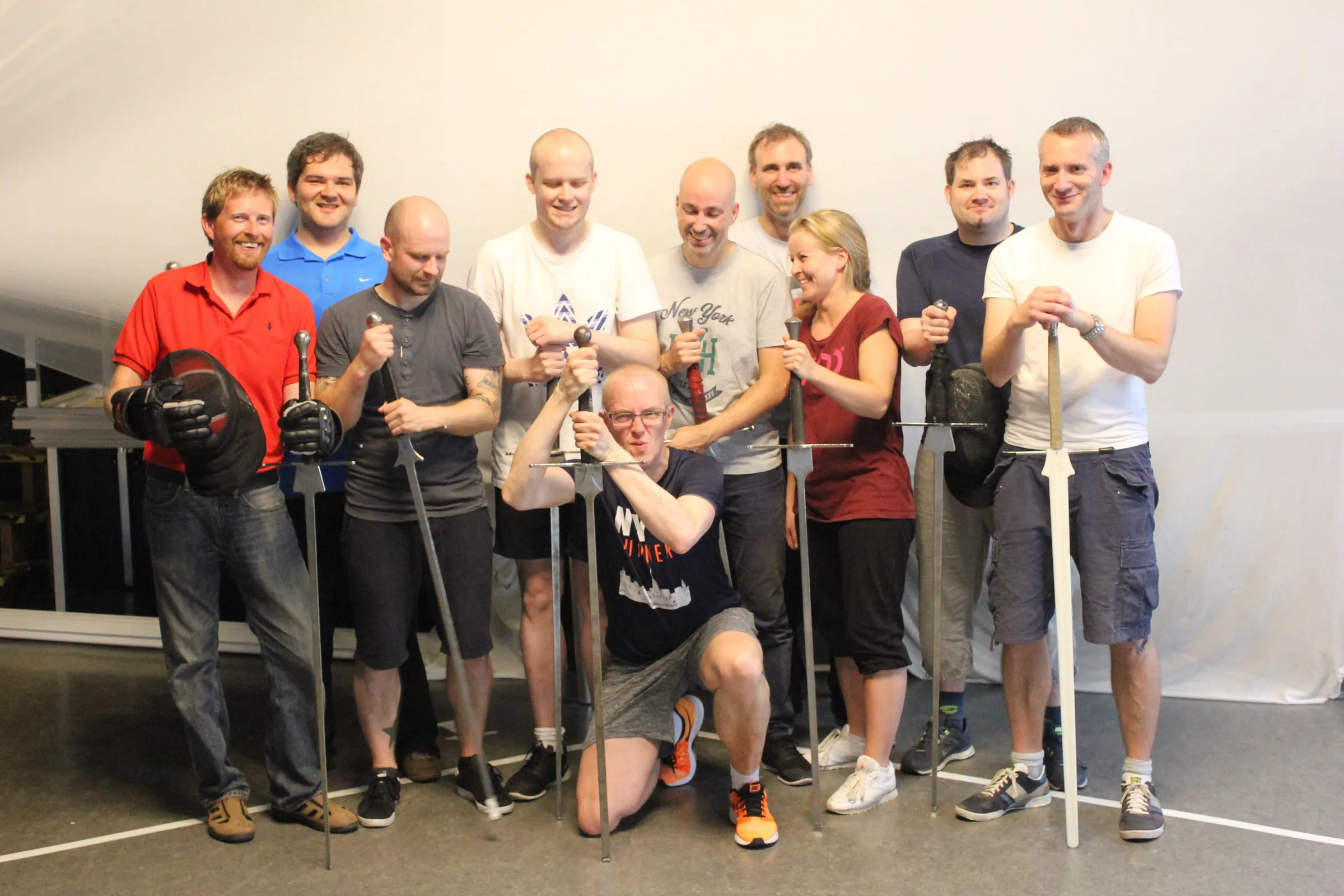 A cheerful group of participants posing with swords after two hours of fencing.