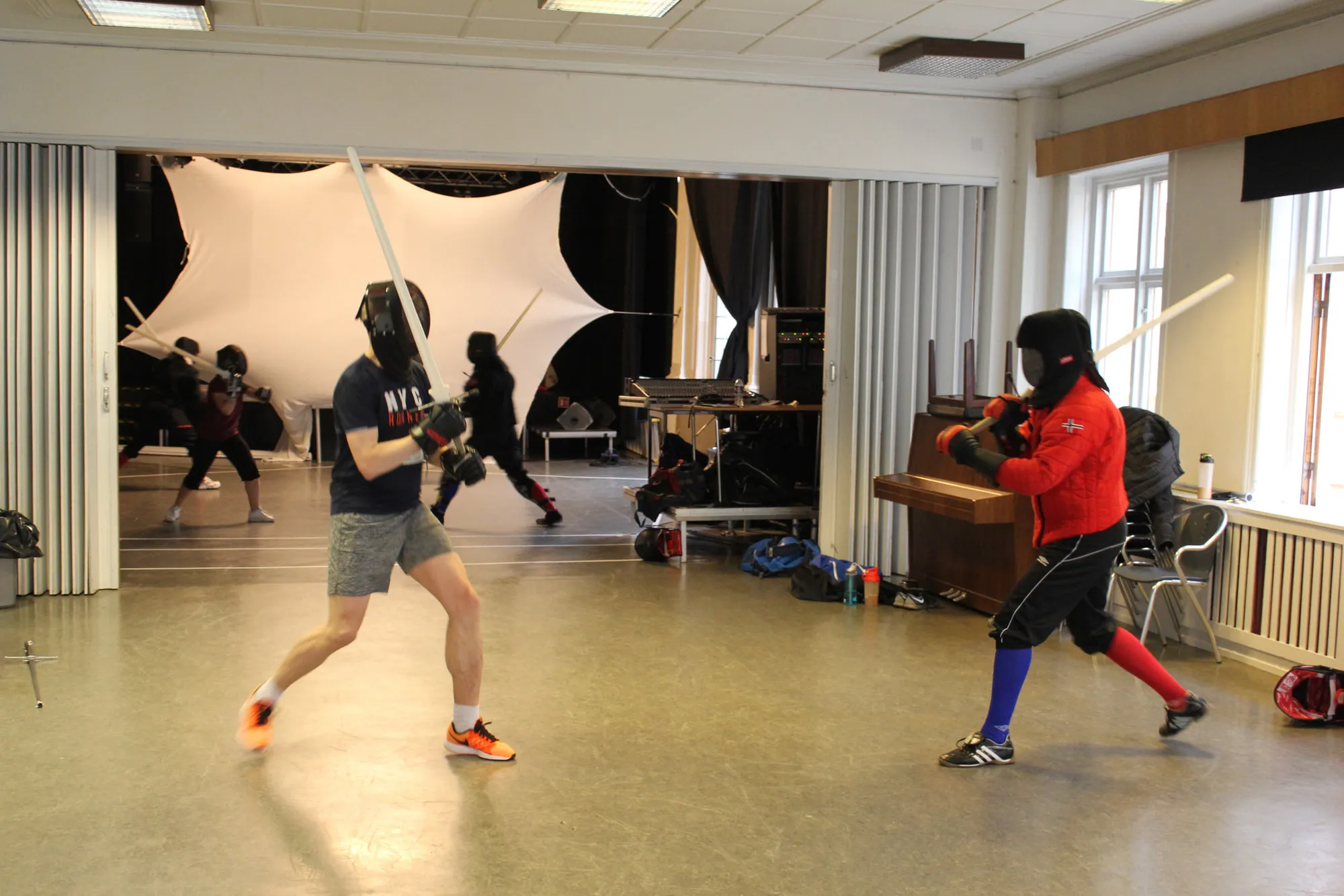 A participant at an event trying their hand at sparring against an instructor in a red jacket.